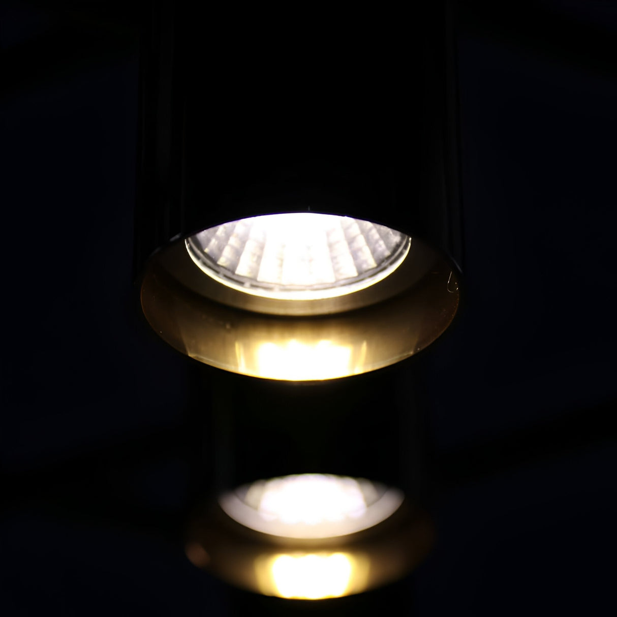 A close-up of the Leonard 19 Light LED Chandelier in Black & Gold, featuring modern design with bright white LEDs in the foreground and softly illuminated lights behind, highlighting energy-efficient lighting.