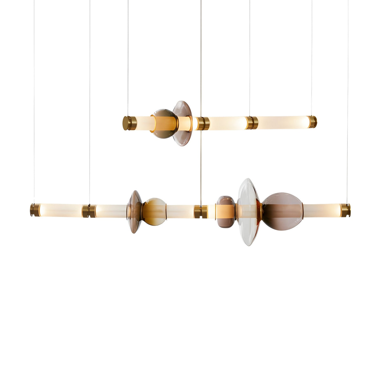 Two Luna LED Linear Double Suspension Lights in gold are hung horizontally, showcasing cylindrical glass rods and decorative amber, clear, and brown accents along their lengths against a white background.