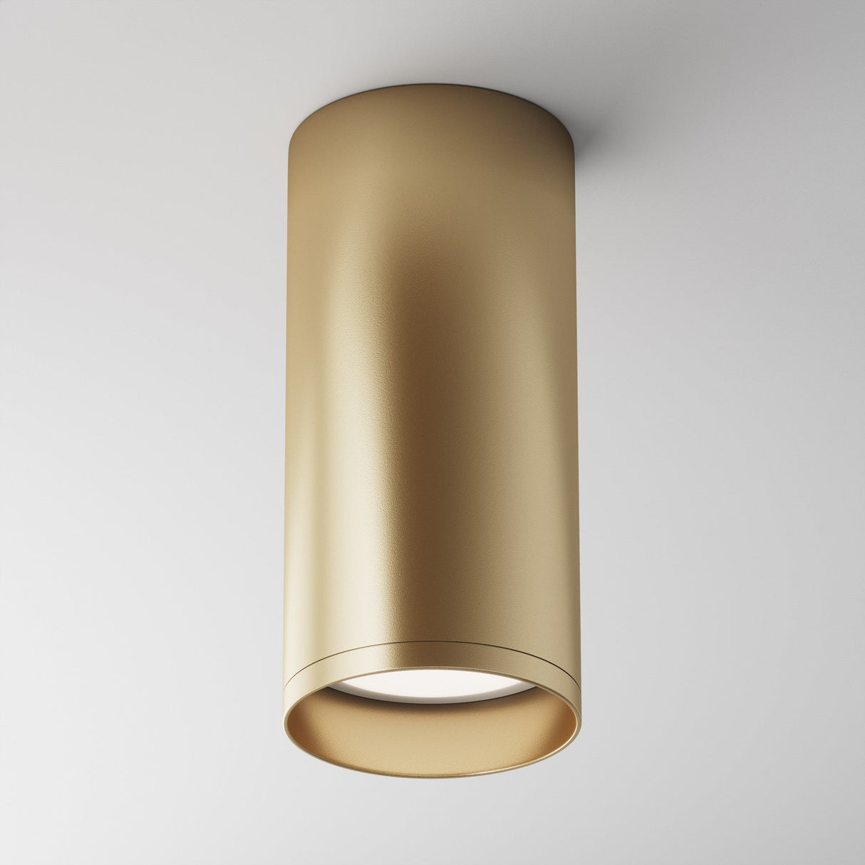 The white ceiling is adorned with the Focus Fixed Round Surface Mounted Downlight in Matte Gold, featuring a smooth, metallic finish that offers a minimalist design and emits a soft downward light.