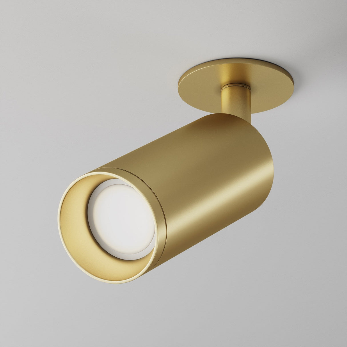 Close-up of the Focus Single Recessed Spotlight in matte gold, with a cylindrical shape and swivel mechanism. It is mounted on a round base attached to the ceiling, featuring a white light source inside.