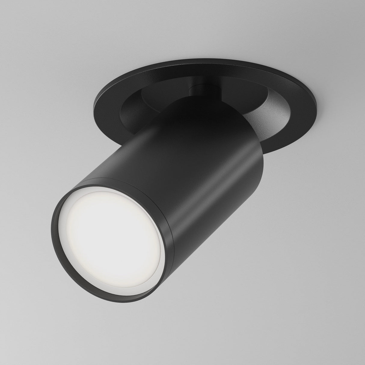 The Focus S Single Recessed Spotlight in black is a chic cylindrical fixture mounted on a white ceiling, directing light gracefully downwards. Perfect for minimalist interiors, it boasts a sleek and modern aesthetic with its refined black finish.