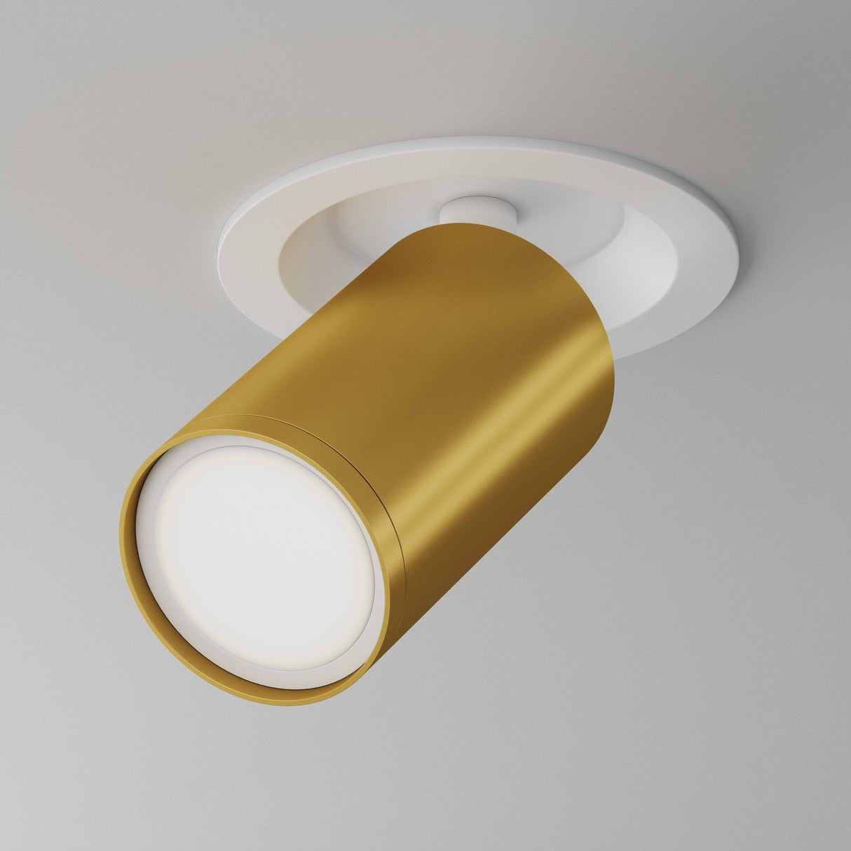 The Focus S Single Recessed Spotlight in white and matte gold seamlessly mounts on a white ceiling as recessed lighting, with its cylindrical design emitting a soft, warm glow.