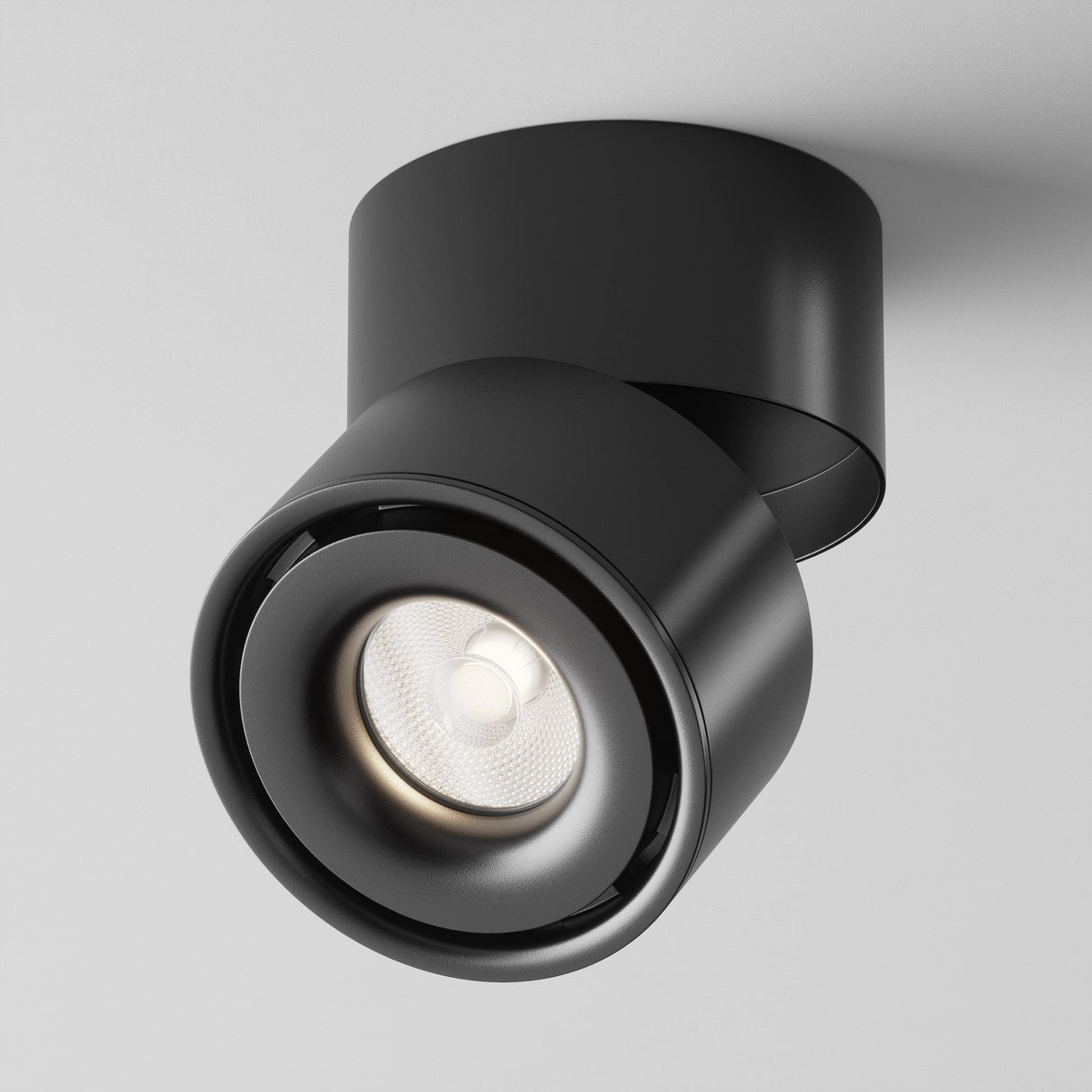 The Yin LED Single Spotlight 15W 4000K in black features a sleek, cylindrical design mounted on a white ceiling. It has a rotatable, round light head for task lighting, combining minimalist and contemporary style with functionality.