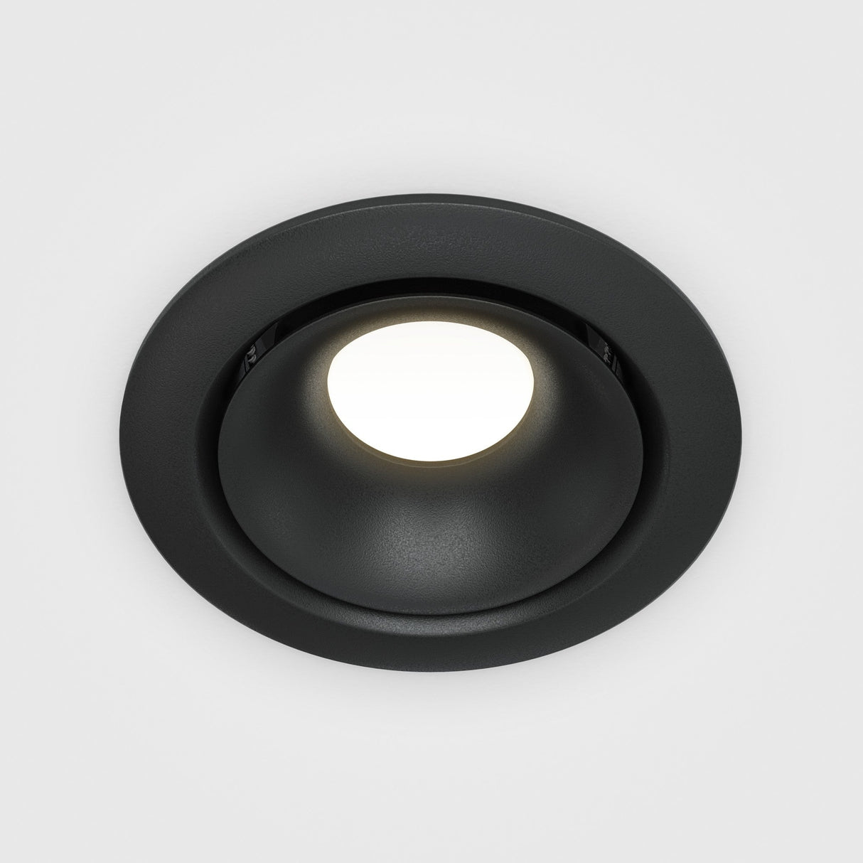 Close-up of the Yin Round Recessed Downlight - Black, featuring a circular design and matte finish. It emits a bright white glow and highlights its dimmable capabilities.