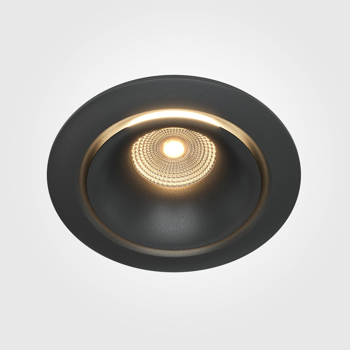 Close-up of the Yin LED Round Recessed Downlight (12W, 3000K) in black. The light emits a soft warm glow with visible interior texture, highlighting the elegance of dimmable lighting.