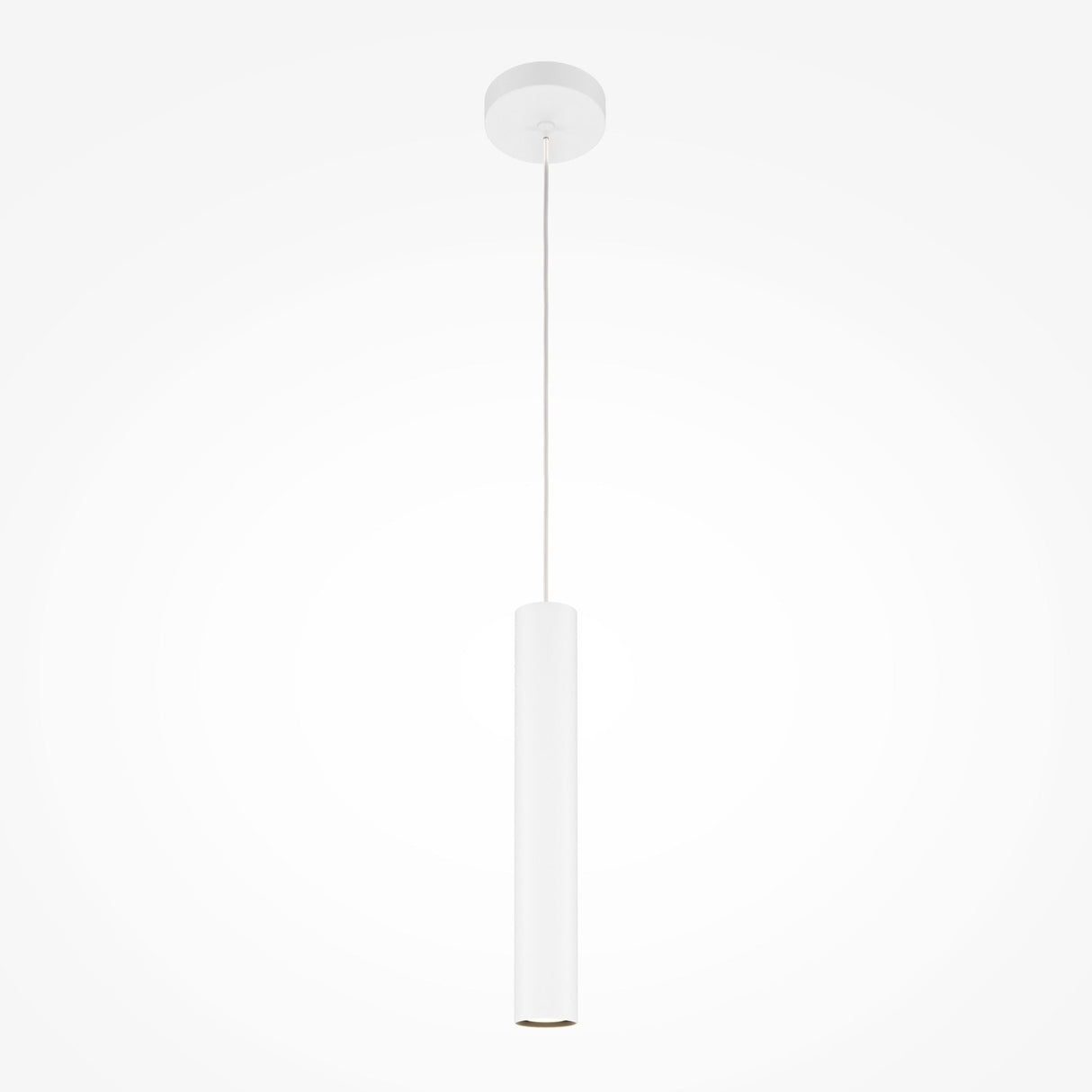 The Pro Focus Thin Pendant Light - White, featuring a minimalist cylindrical white shade, hangs from a slim cord connected to a round ceiling mount, with the plain white background enhancing its ambient lighting effect.