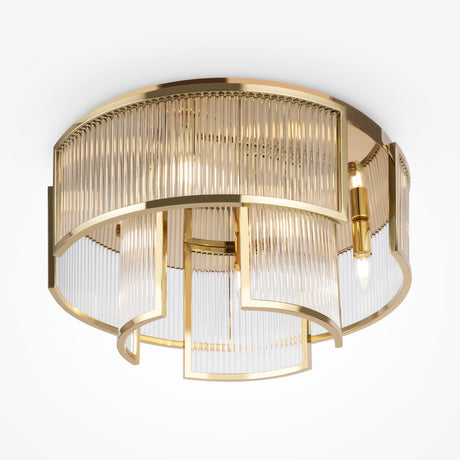 The Frame 6 Light Flush - Gold features a geometric frame and cylindrical glass panels, with overlapping arcs and vertical ridges housing multiple bulbs. This chic gold fixture is perfect against a plain white backdrop, making it a true statement piece in modern lighting design.