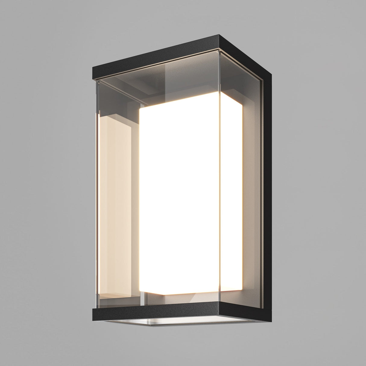 The Baker Street Outdoor LED Wall Light - Black (O021WL-L10B4K) features a modern rectangular design with a frosted glass enclosure and black metal frame. It glows softly, creating warmth against a gray background, and has an IP65 rating for durable, energy-efficient performance.