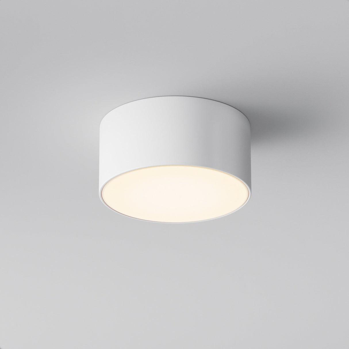 The Zon Outdoor Ceiling Light 15W 3000K in white is a minimalist, cylindrical LED fixture that softly illuminates a room. With its simple, modern design and IP65 rating, it performs reliably on a smooth, light gray ceiling even in varied conditions.