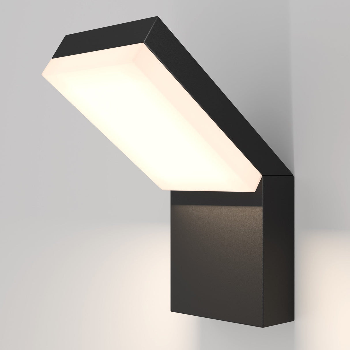 The Paso Outdoor LED Wall Light 3000K in black features a modern, angular design with a rectangular fixture that emits downward light, blending seamlessly into pale walls. Its ideal for enhancing outdoor spaces with stylish and efficient illumination.