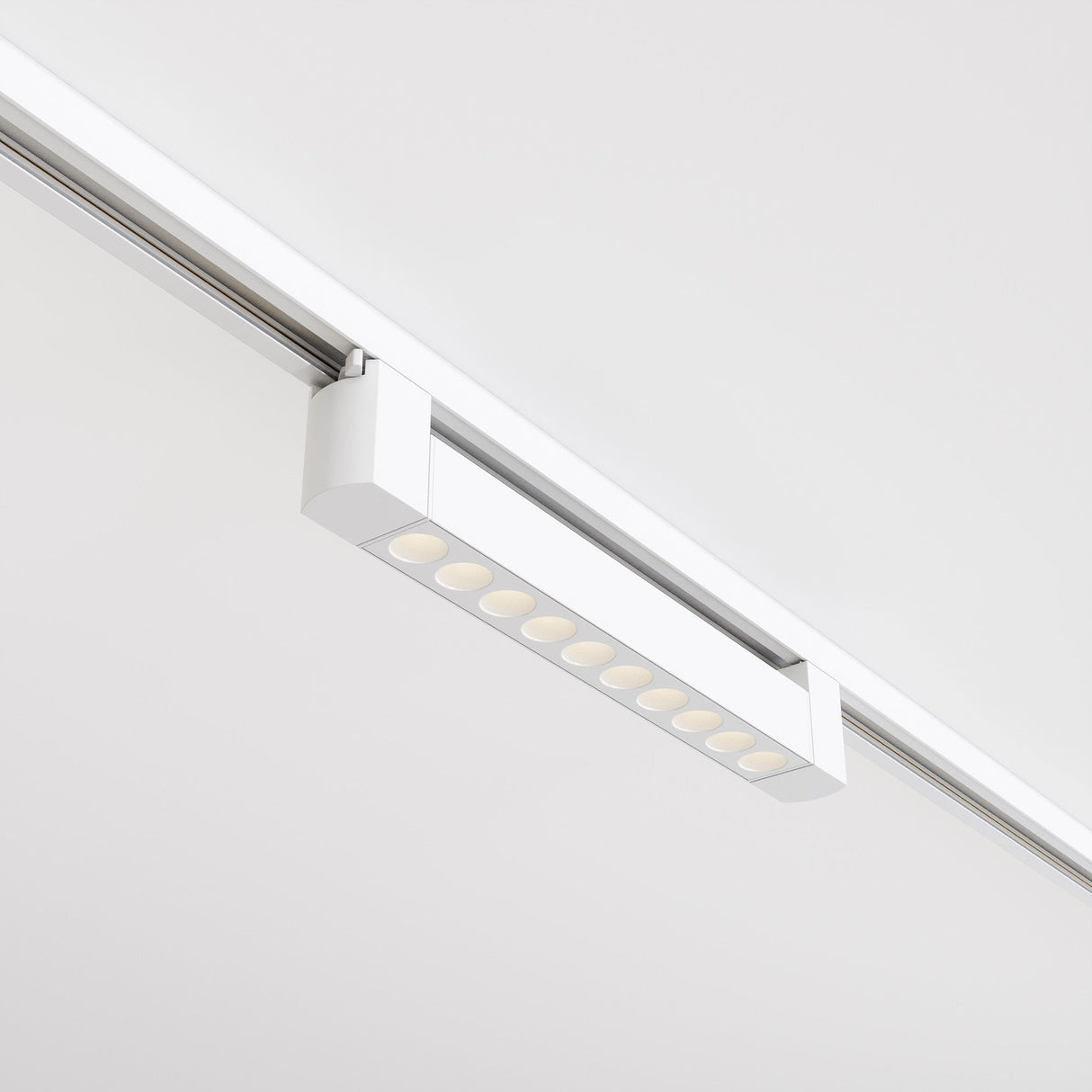 The Points Rot LED Swivel Linear Track Light for Single Phase Track Unity 10W 3000K 36°- White is a rectangular ceiling fixture with multiple light sources along a silver track, boasting a high color rendering index and creating a modern look against the white ceiling.