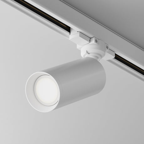 The Focus 3-Circuit Trinity Track Spotlight features a sleek, cylindrical design on a metal track. Its adjustable, downward lighting complements its modern look against a gray ceiling and ensures optimal illumination with GU10 base compatibility.