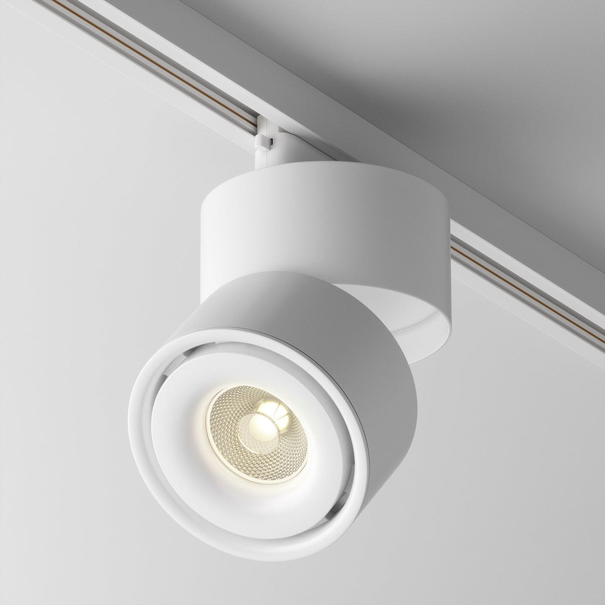 The Yin LED Single Phase Unity Track Spotlight 15W 3000K in white features a circular, cylindrical design. It mounts on ceilings, displaying a visible bulb that casts soft light at a 3000K color temperature and enhances contemporary interior aesthetics with its minimalist style.