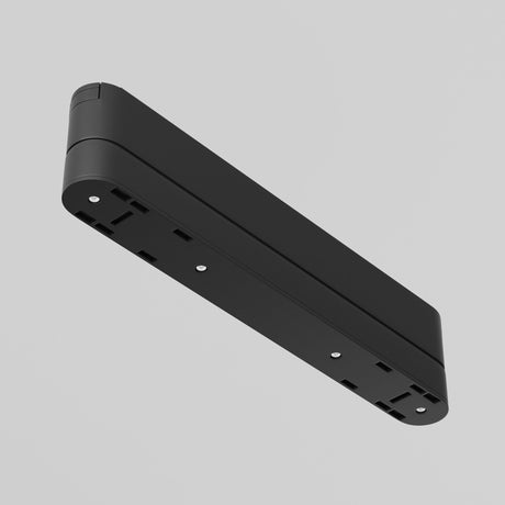 The Radity Magnetic Track Long Adaptor - Black features a sleek, black rectangular design with three outlets, set vertically against a gray background. Its minimalistic build and durable construction give it an elegant appearance as if floating in the air.