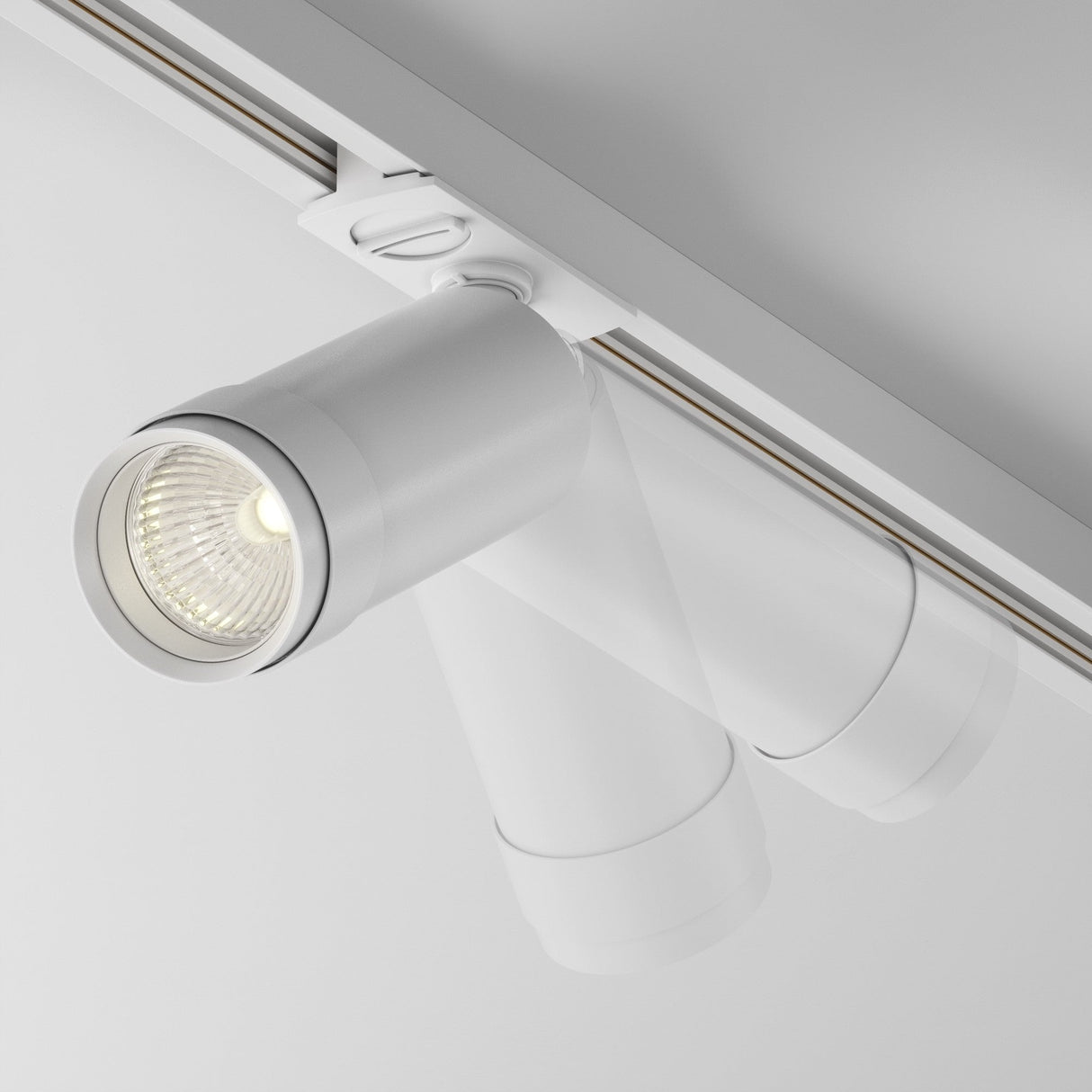 Close-up of the Focus Zoom LED Dimmable Single Phase Unity Track Spotlight 12W 3000K in white, mounted on a ceiling. It emits a soft glow with its sleek design and adjustable angles for directing glare-free lighting.