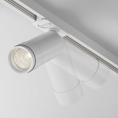 The Focus Zoom LED Single Phase Unity Track Spotlight 12W 3000K - White, with its cylindrical design and ceiling-mounted structure, features a visible downward-facing bulb offering a sleek, minimalist look with customizable beam spread.
