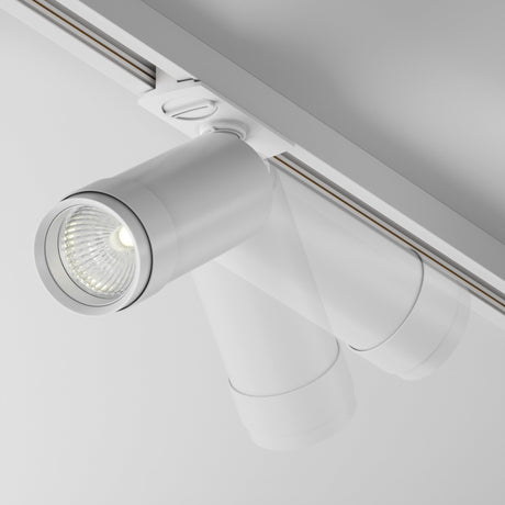 Close-up of a Focus Zoom LED Dimmable Single Phase Unity Track Spotlight 12W 4000K in white, featuring a visible bulb and cylindrical shape. Its mounted on a rail, angled slightly downward, casting a soft, neutral light on the surface below with its sleek design.