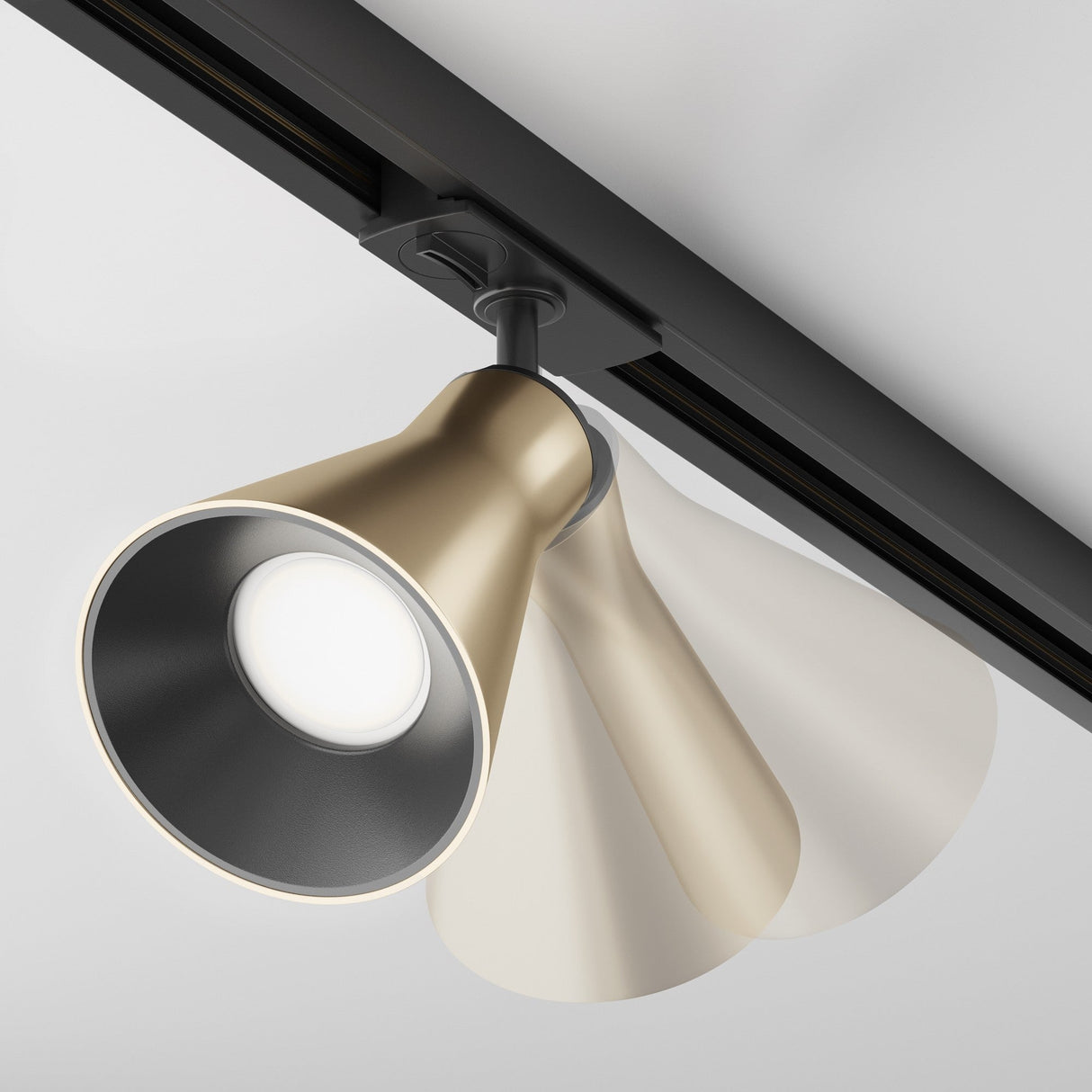 The Virar Single Phase Unity Track Spotlight in matte gold features a sleek, conical design mounted on a dark track. Its adjustable swivel mechanism allows for dynamic accent lighting with a bright, focused beam, enhanced by a blurred effect that suggests motion or rotation.