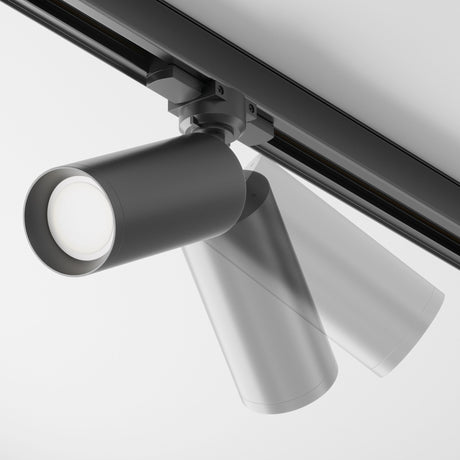 The Focus 3-Circuit Trinity Track Spotlight - Black is a sleek and modern ceiling-mounted fixture with a cylindrical spotlight featuring a circular LED bulb. Its perfect for contemporary spaces, offering adjustable positioning and focus on its linear rail.