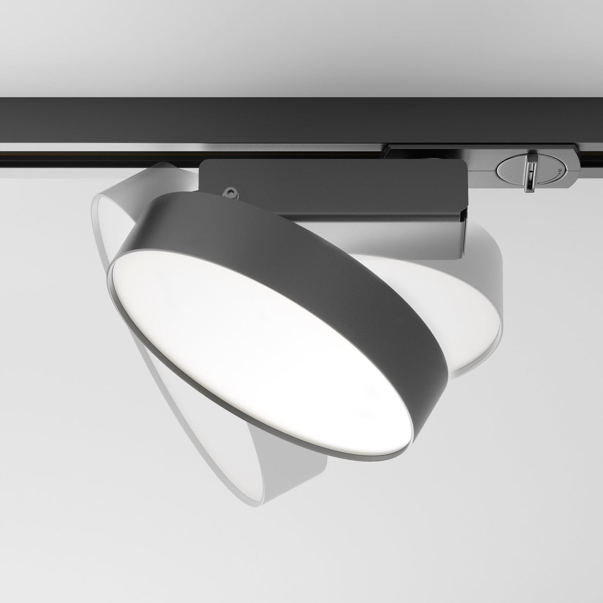 A sleek black Zon LED Single Phase Unity Track Spotlight 12W 4000K is ceiling-mounted, featuring a large circular white light with an adjustable angle. This modern fixture casts bright illumination with minimalist and contemporary design.
.