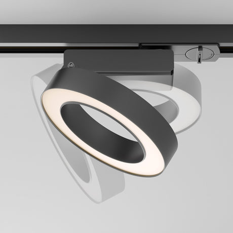 The Rim LED Single Phase Unity Track Spotlight 12W 3000K in black features a modern circular design with a white interior. Adjustable for optimal lighting, it casts an angled shadow and enhances contemporary interiors with its sleek aesthetics.