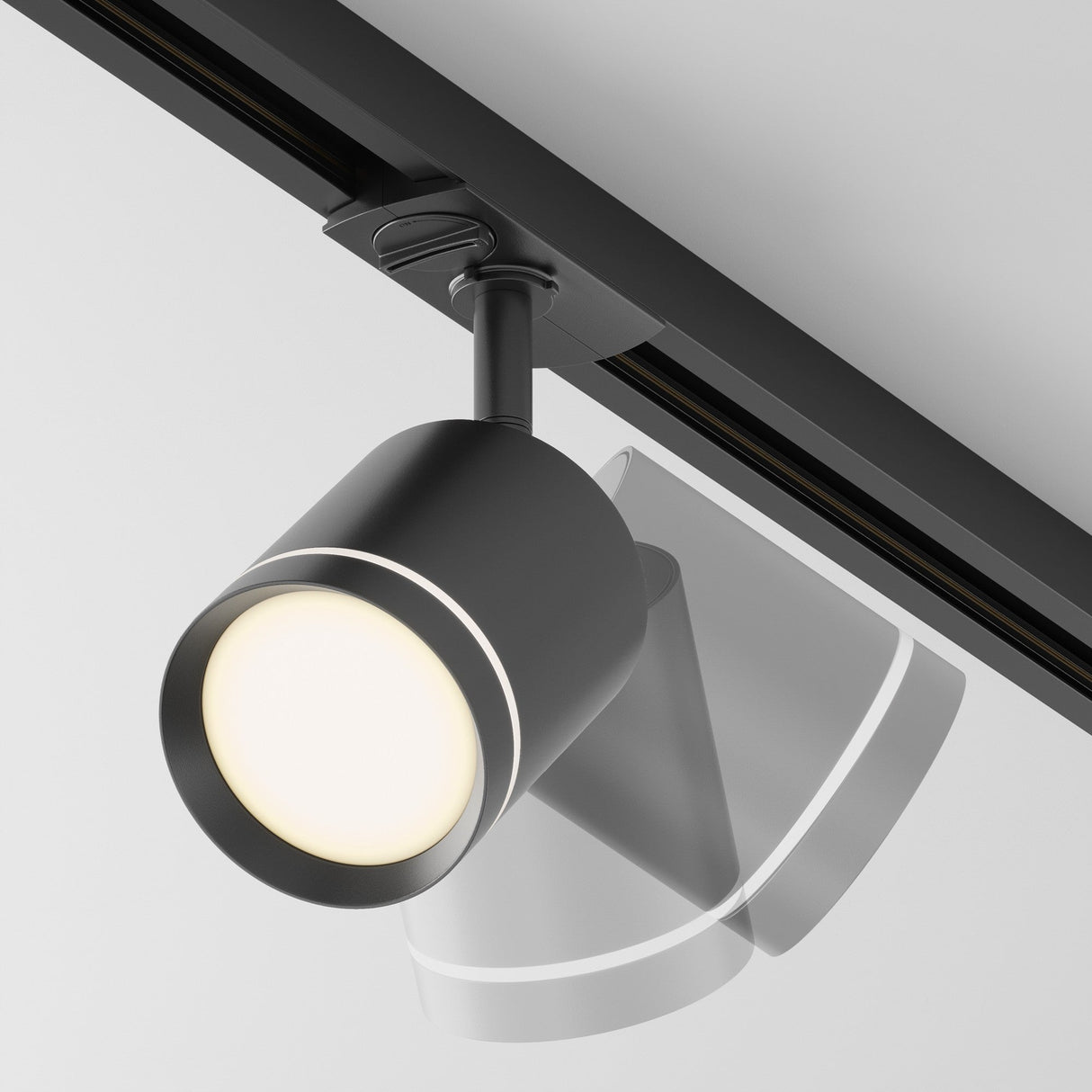 The Orlo LED Single Phase Unity Track Spotlight 5W 3000K - Black, with its sleek cylindrical design, mounts on the ceiling to cast a bright glow. It enhances contemporary interiors and offers adjustable tilting for perfect accent lighting through its intriguing shadow effect.
