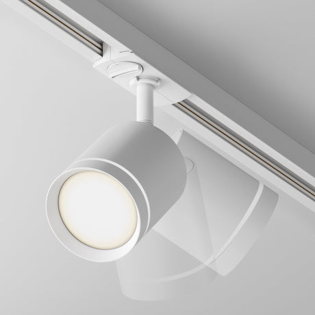 Close-up of the Orlo LED Single Phase Unity Track Spotlight 5W 4000K - White, featuring a cylindrical design. Mounted on a single-phase track system, it emits a soft glow at 4000K against a plain white ceiling, enhancing its minimalist aesthetic.