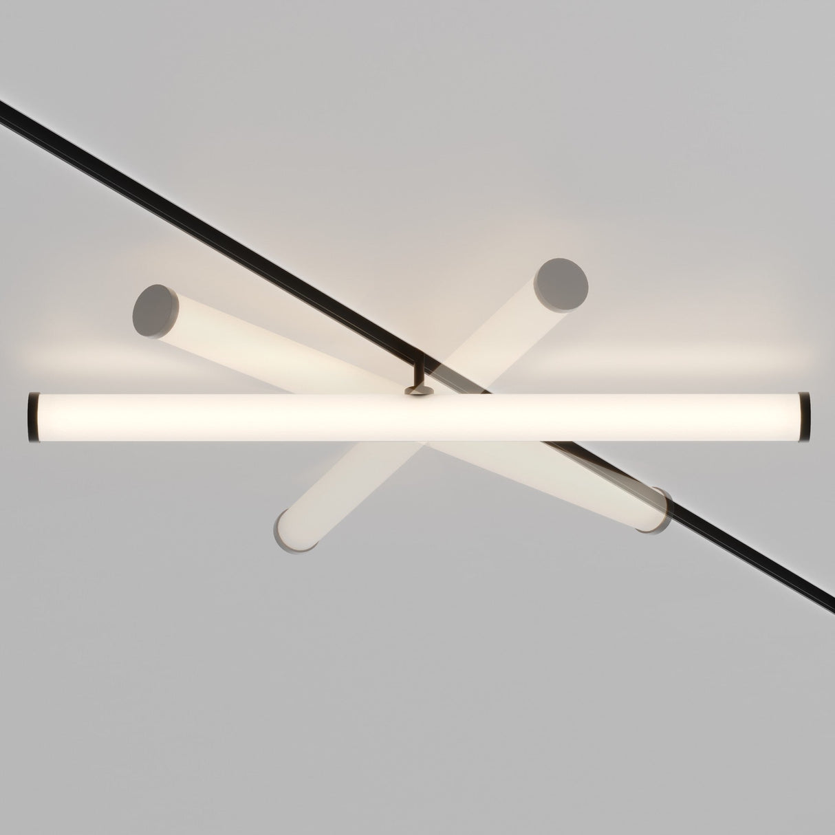 The Larc LED Rotating Linear Track Light for Magnetic Exility features two intersecting cylindrical rods emitting a soft white glow at 25W 3000K, mounted on a thin black bar for an energy-efficient, modern design against a plain white ceiling.