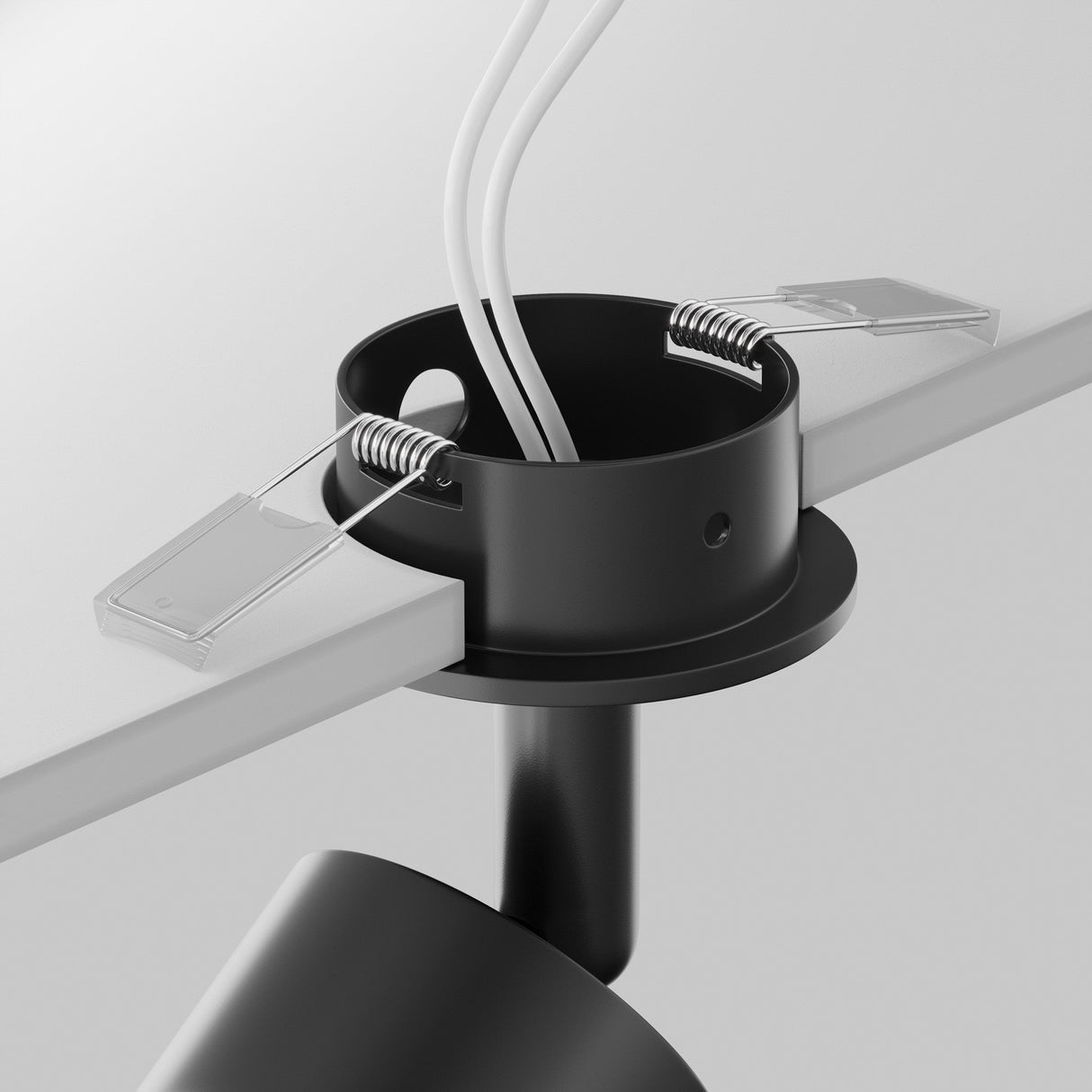 The Focus Single Recessed Spotlight - Black, with its black cylindrical housing partially inserted into a white ceiling panel, showcases contemporary design. It features two metal spring clips and three white wires, with an adjustable bulb holder seamlessly extending below the ceiling.