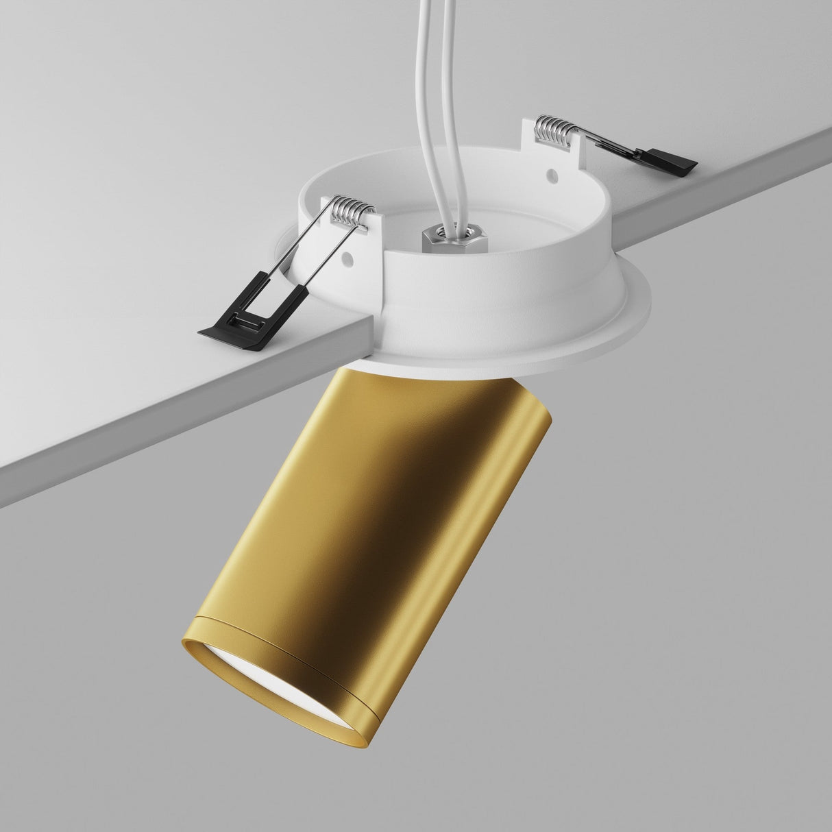 The Focus S Single Recessed Spotlight in matte gold with a white mounting fixture is installed on the ceiling, revealing wires and clips against a plain gray background, highlighting the stylish blend of recessed lighting elements.