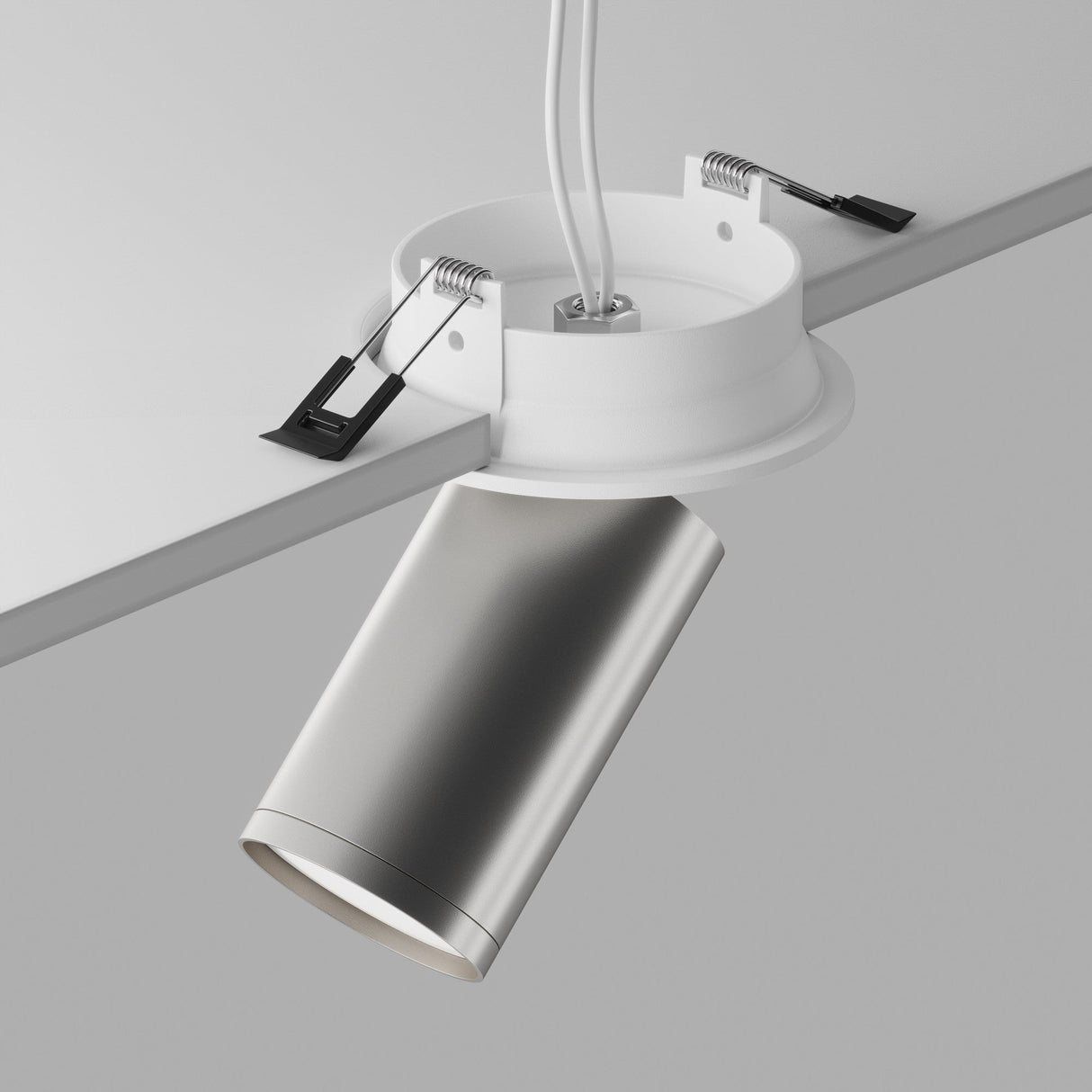 The Focus S Single Recessed Spotlight in white and silver, featuring a modern cylindrical design and 360° swivel mechanism, is being installed in a ceiling. Its sleek metallic look contrasts with the neutral background, showcasing the white mounting bracket with visible wiring and clips.