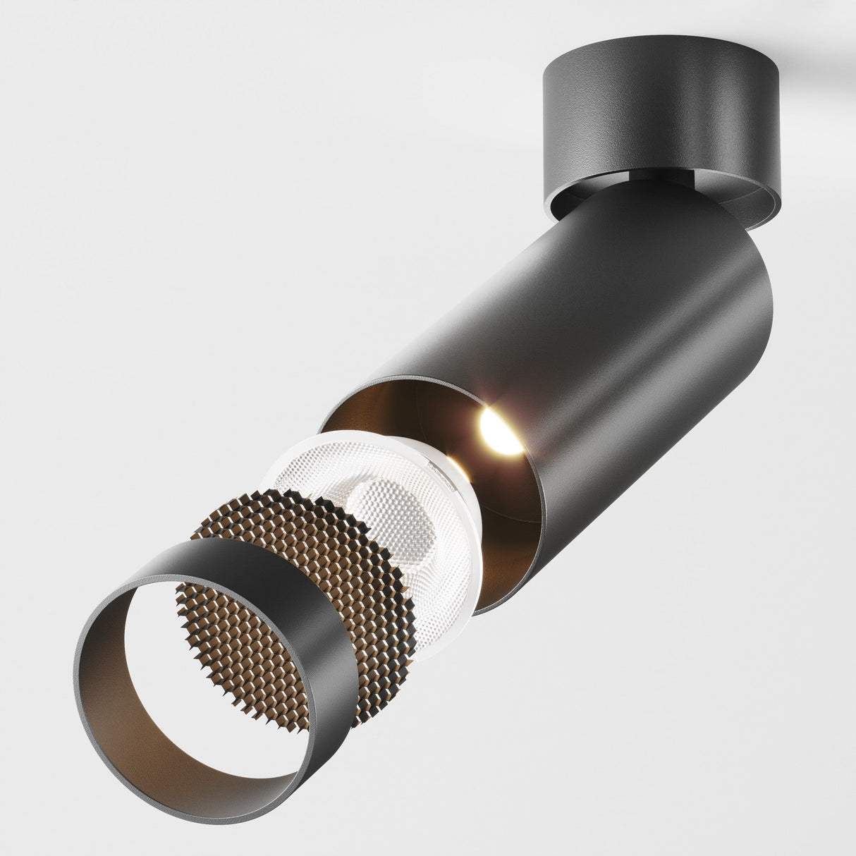 The Focus LED Dimmable Single Spotlight 12W 3000K in black features a modern cylindrical design with a visible LED bulb. A partially honeycomb-patterned diffuser adds industrial flair, and its dimmable feature allows for customized ambiance, all against a sleek white background.