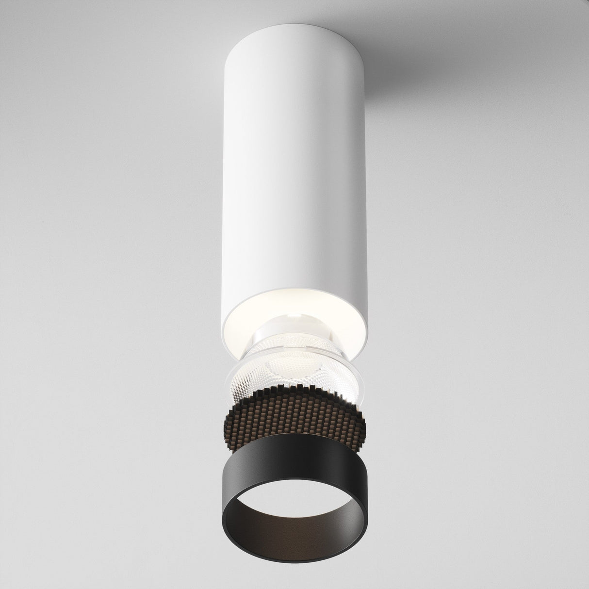 The Focus LED Dimmable Fixed Round Surface Mounted Downlight 12W 4000K - White features a modern cylindrical design with a visible interior bulb and black ring, offering an energy-efficient blend of style and functionality against a minimalist gray background.