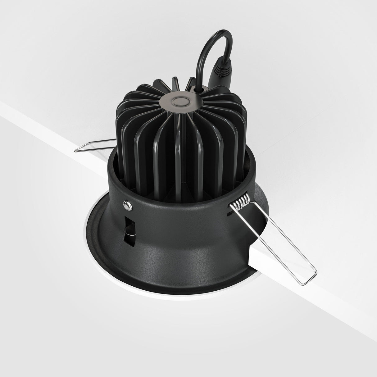 The Yin LED Round Recessed Downlight 12W 4000K is elegantly installed in a white ceiling, featuring a black heat sink, silver spring clips, and a black power cable for optimal lighting performance.