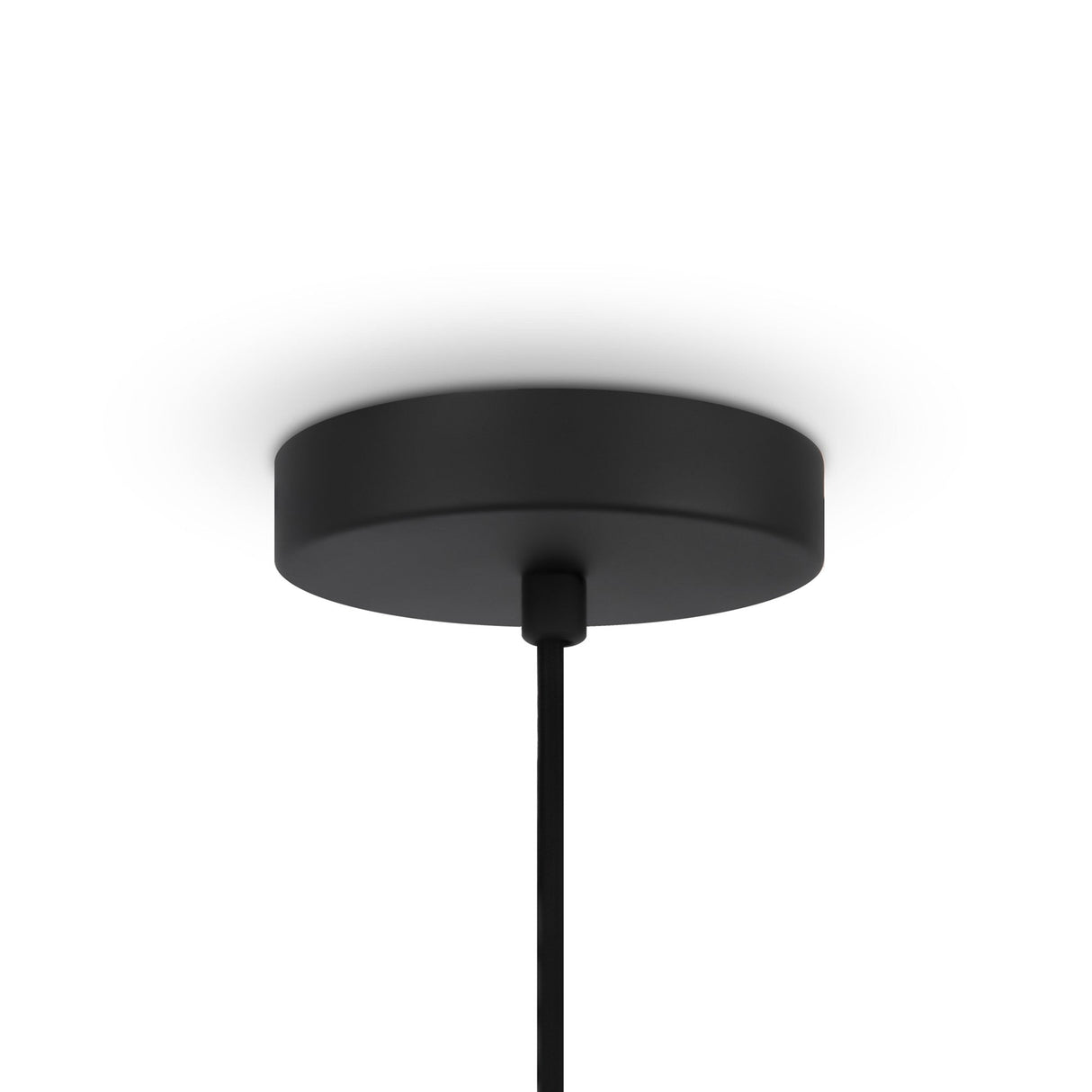 A black cylindrical ceiling canopy with a single cable extends downward, showcasing contemporary elegance. This minimalist design complements a plain white ceiling, reminiscent of the refined style captured in the Roots Pendant Light 60cm - Black & Natural Wood Sphere Rings collection.