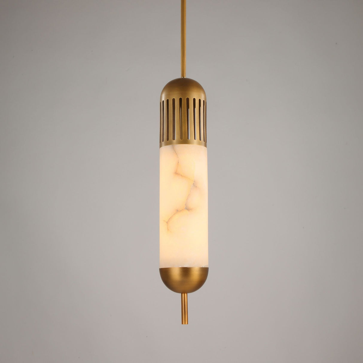 Zerith LED alabaster tube pendant light with fluted brushed brass collar and domed brass base cap, on a plain grey background.
