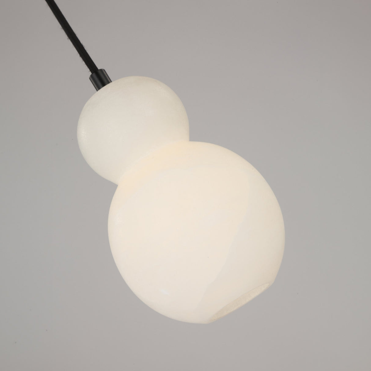 Niori Orlune LED sculpted pear pendant light in soft white Spanish alabaster, illuminated double-gourd form on a black cord against a plain grey background.