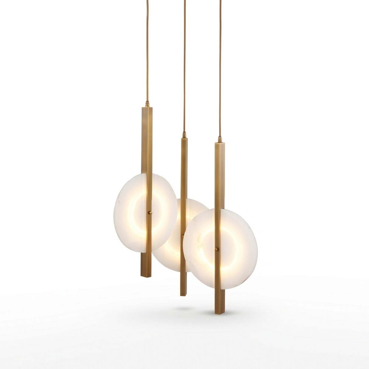 Niori Elyra 3 light cluster chandelier with staggered flat oval alabaster discs on brushed brass blade stems, shown against a white background.