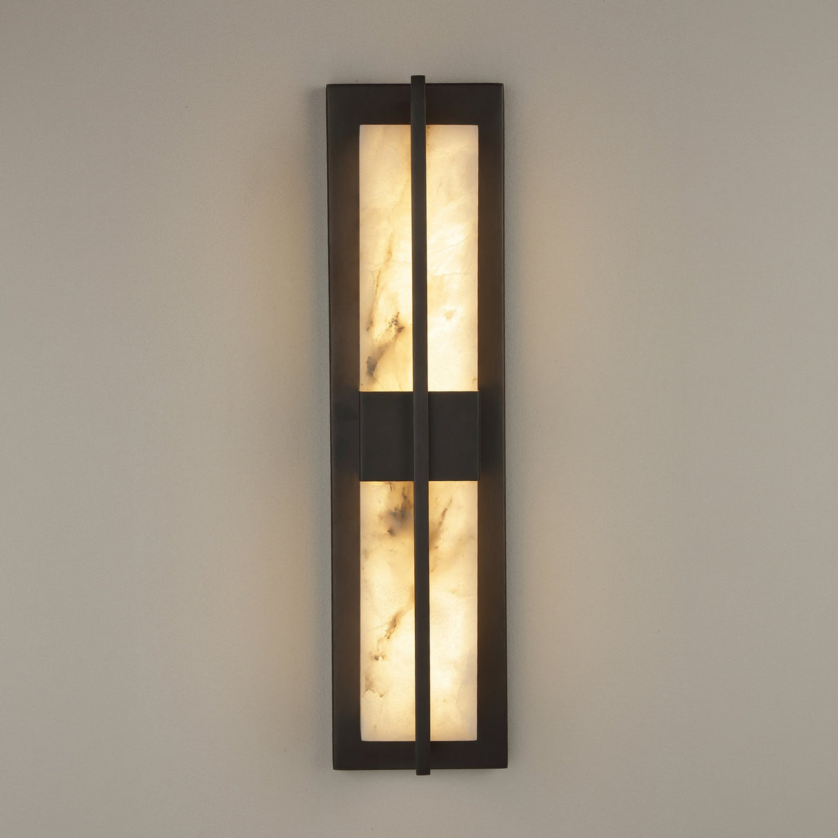 Niori Caldera LED wall light in matt black with two vertical Spanish alabaster panels split by a central bar, mounted on a pale wall.