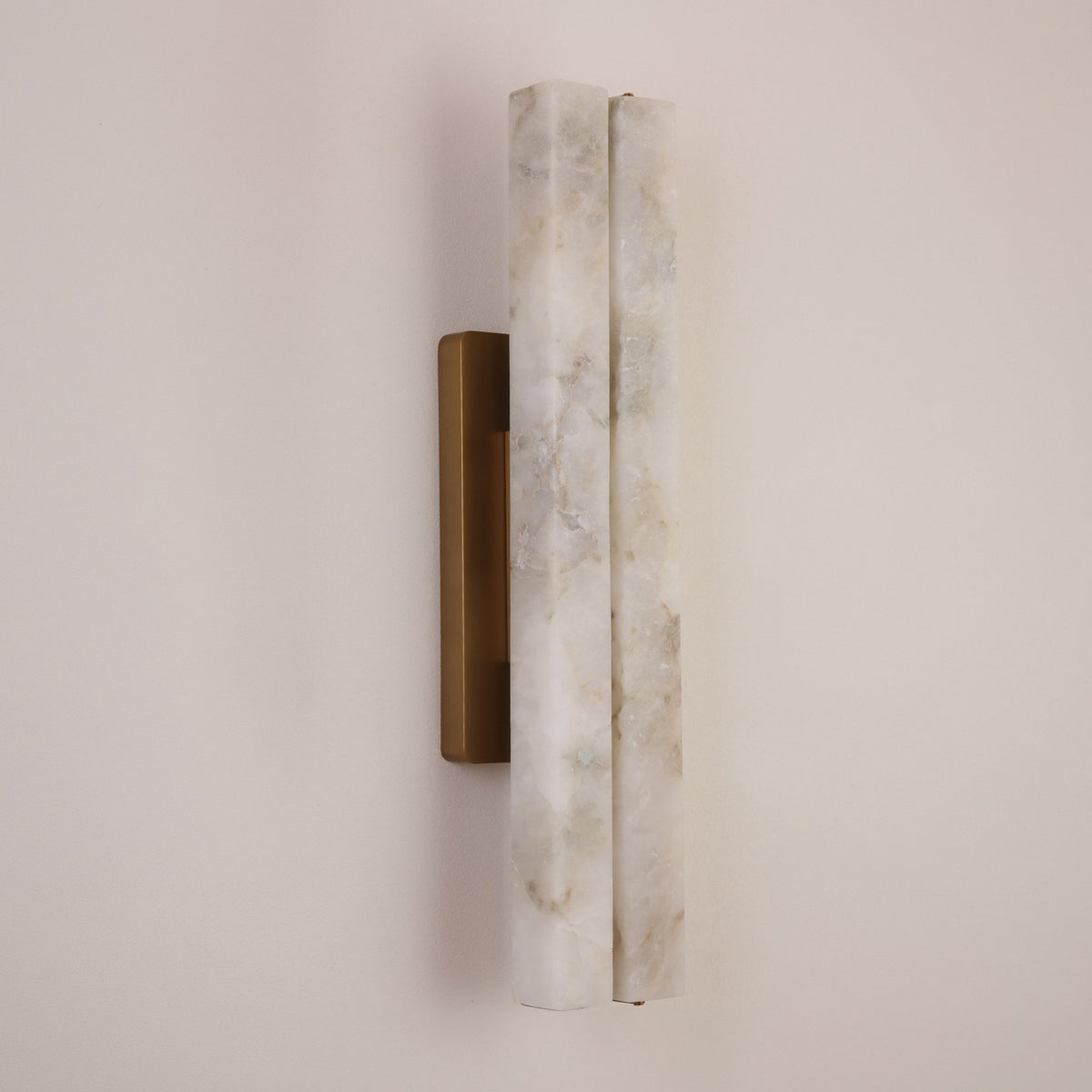 Selvara LED Large Alabaster Double Wall Light with two vertical alabaster columns on a brushed brass backplate, mounted on a plain light wall.