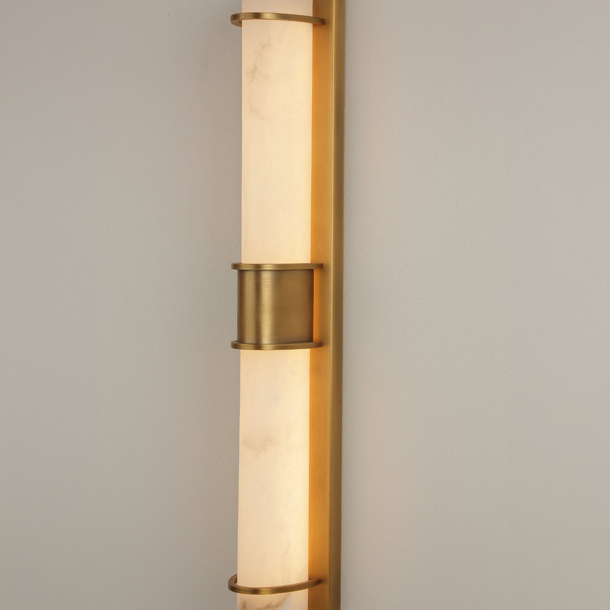 Averna LED framed alabaster wall light by Niori, with stacked cylindrical alabaster columns held in a brushed brass frame and central collar.