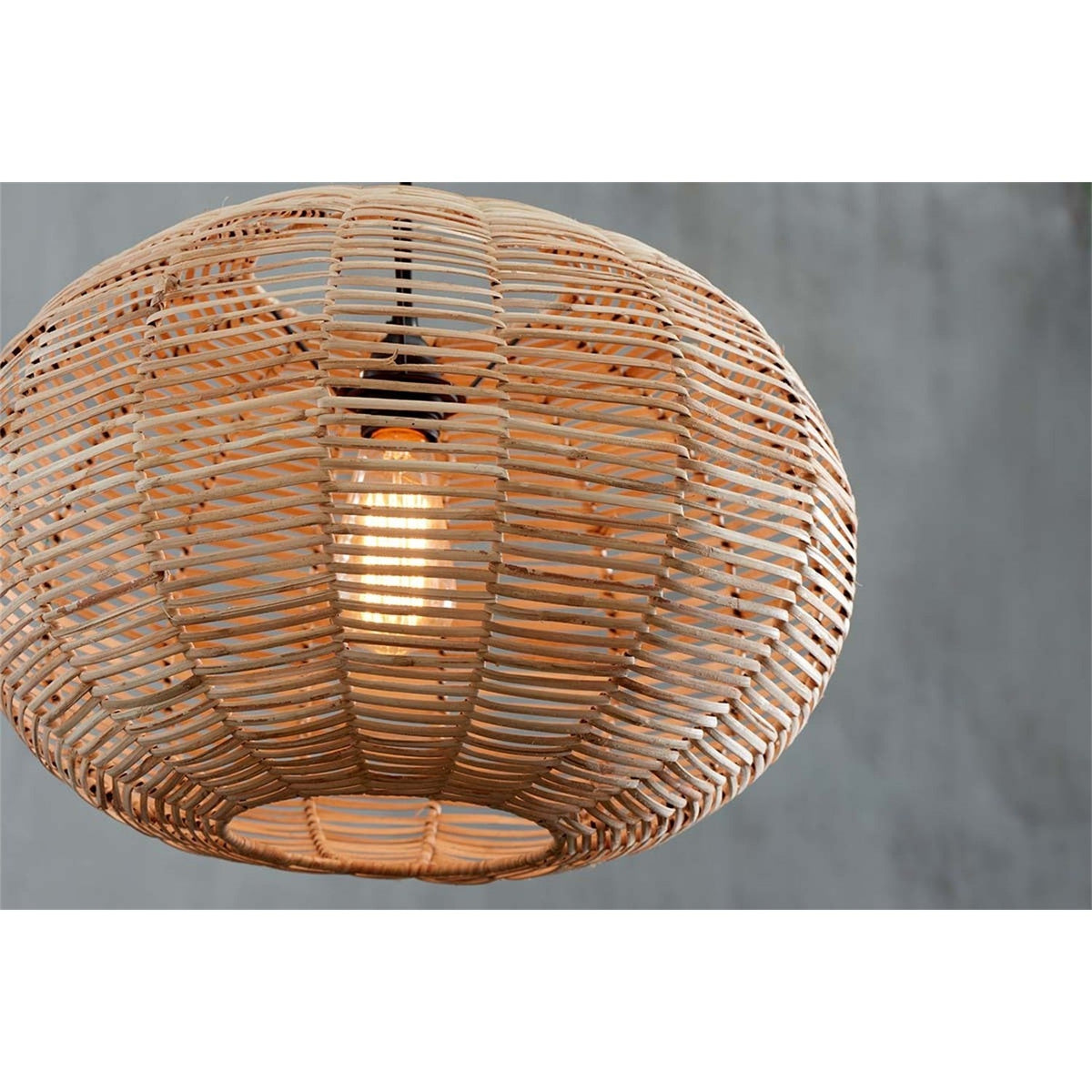 Close-up of the Noko Large Wicker Round Pendant Light in natural, showing its flattened globe shape with open woven ribs and a visible bulb inside, against a grey background.