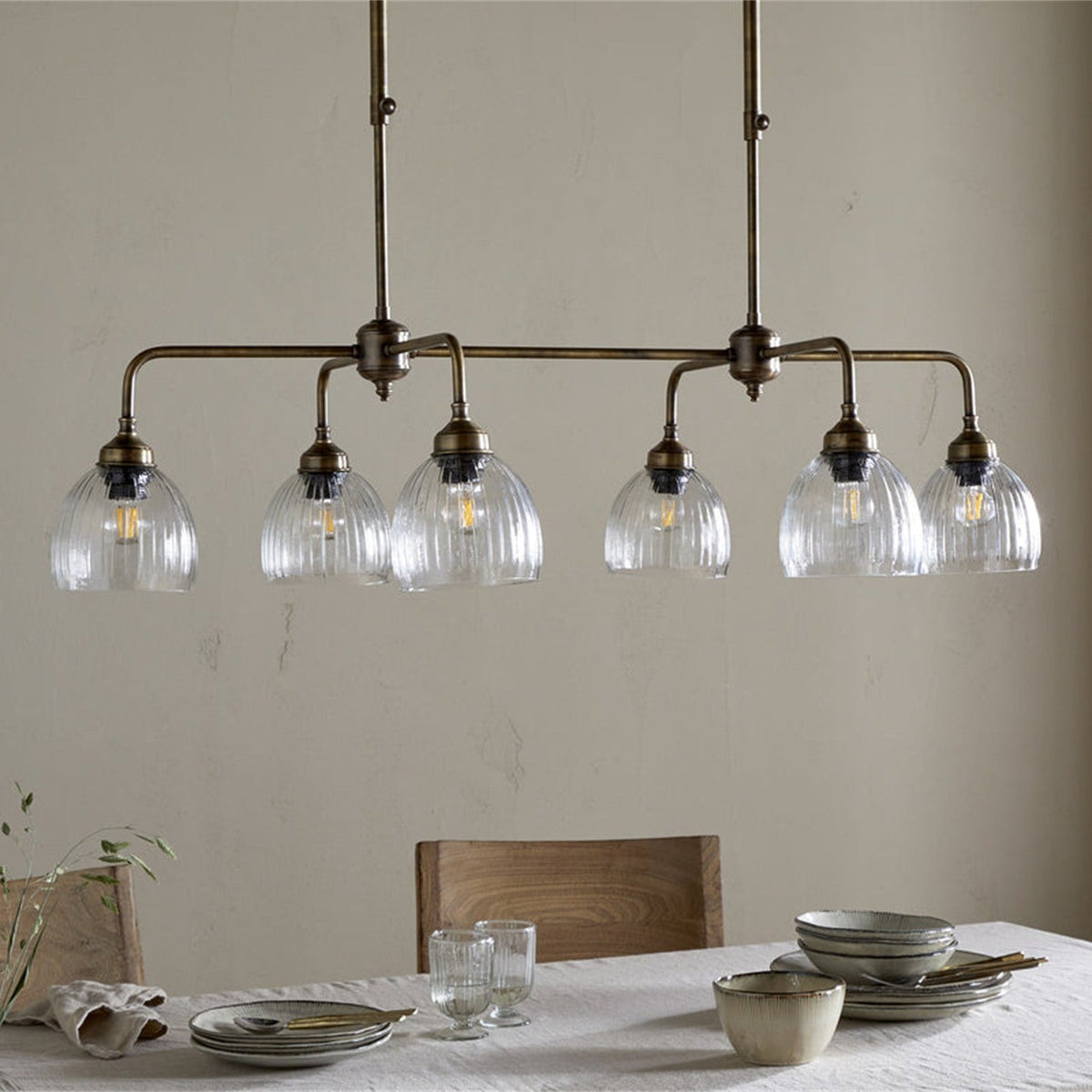 Kakira Ribbed Glass 6 Light Chandelier - Clear & Antique Brass in a kitchen