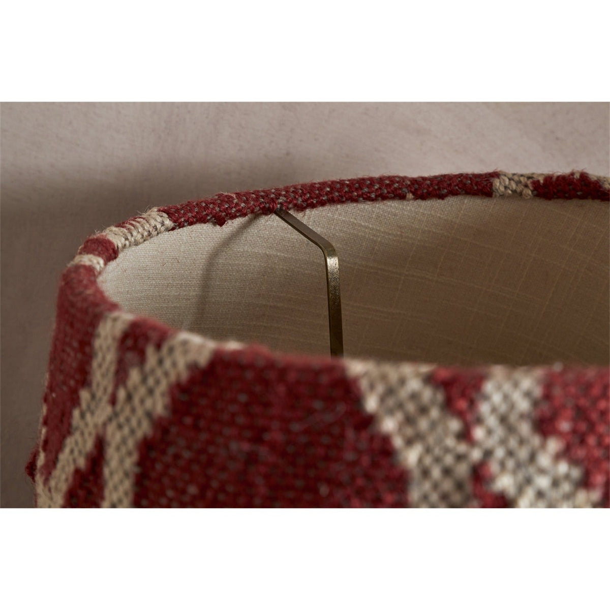 Close-up of the Haadu Large Jute Kilim Lampshade, showing rust and natural woven wool fabric, cream lining, and the brass gimbal fitting inside.