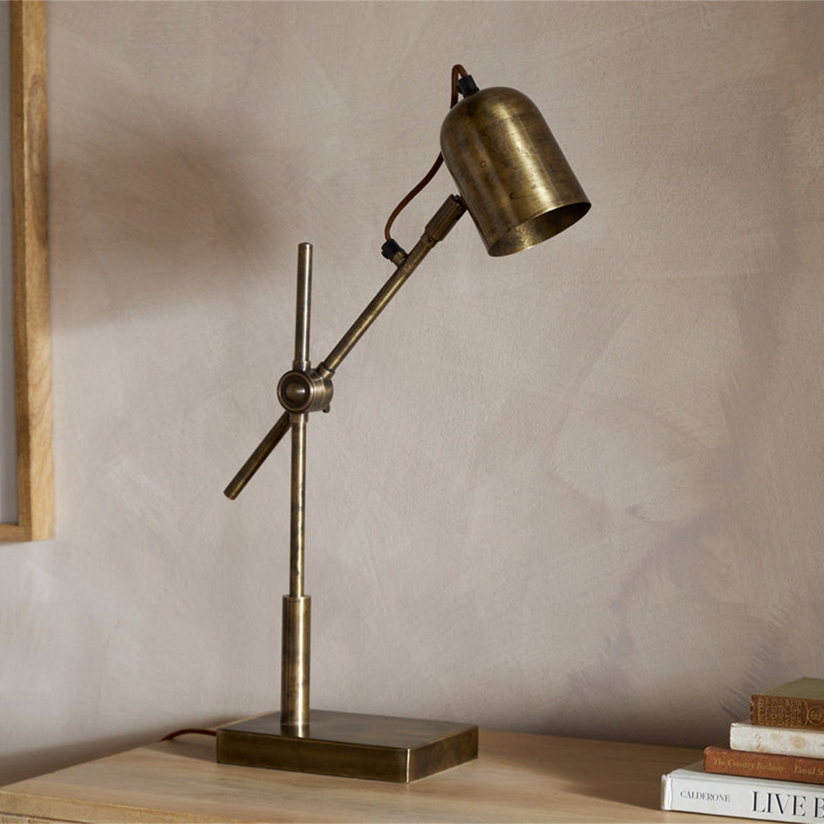 Thenkara Directional Desk Lamp - Antique Brass in a study, view 2