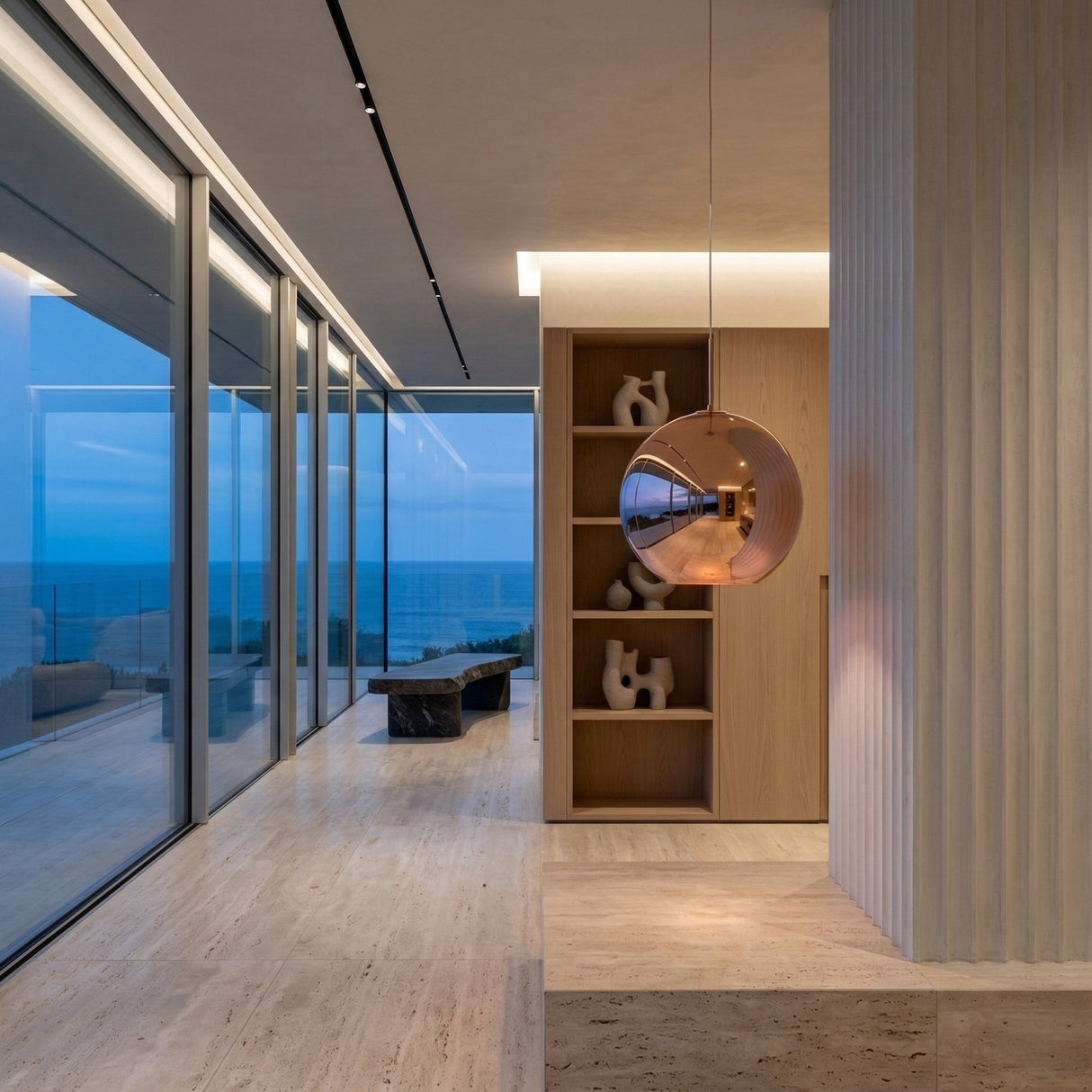 A modern interior with floor-to-ceiling ocean views, light wood floors, a marble bench, built-in wooden shelves with abstract decor, and the striking Grand Ball Glass Pendant 40cm in Copper.
