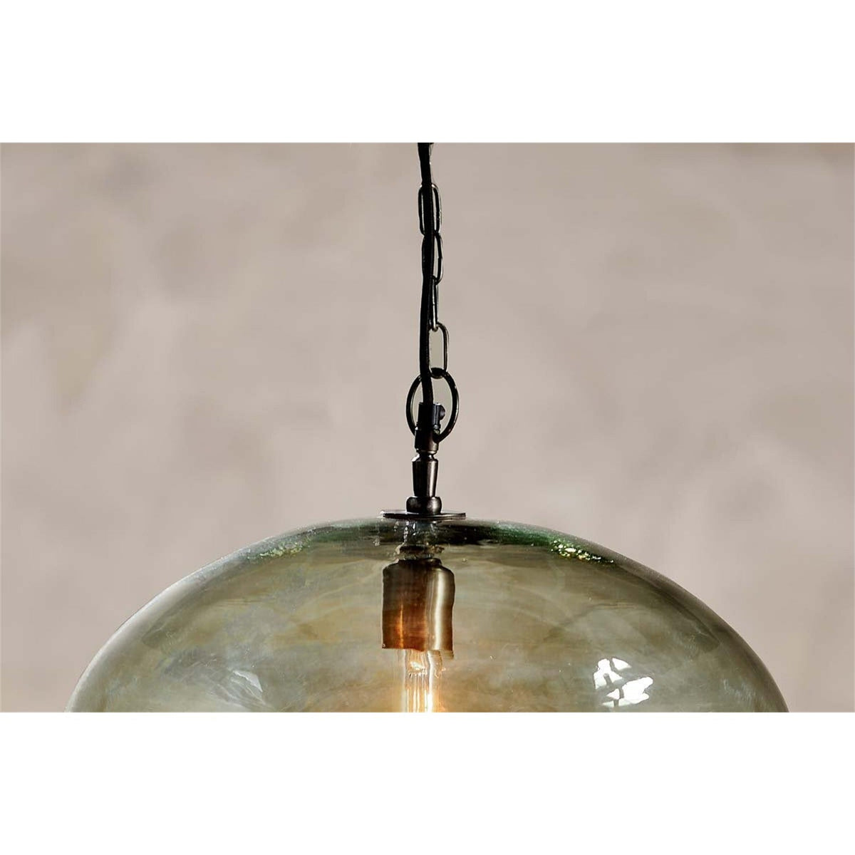 Otoro Large Round Recycled Glass Pendant Light in green, close-up of the smoky glass dome with brass collar, chain suspension and visible bulb, set against a plain background.