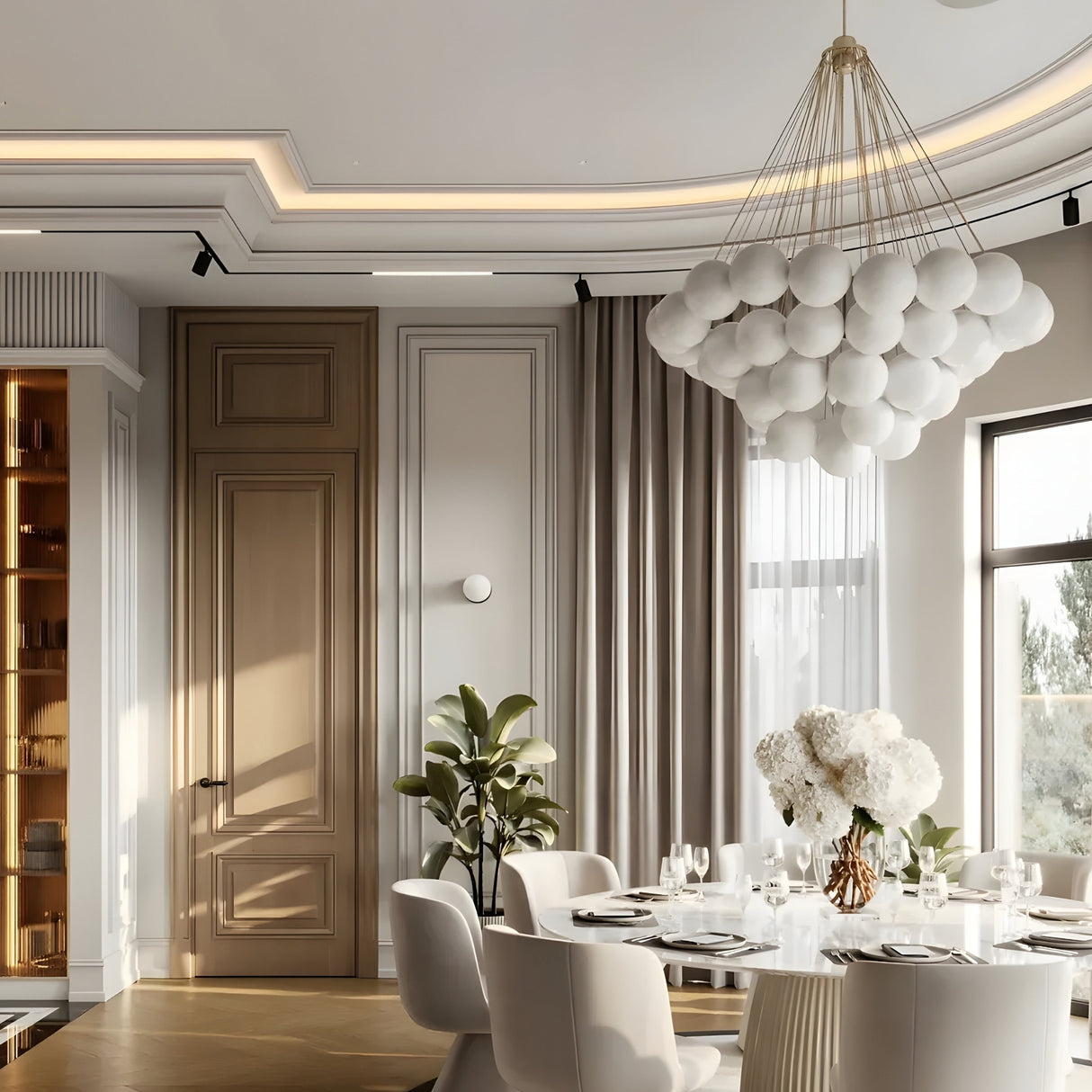 A modern dining room with a round table for six, white chairs, tall curtained windows, and the Orb 37 Light Cluster Suspension in Silver with frosted glass spheres, wood accents, built-in shelves, and neutral-toned walls.