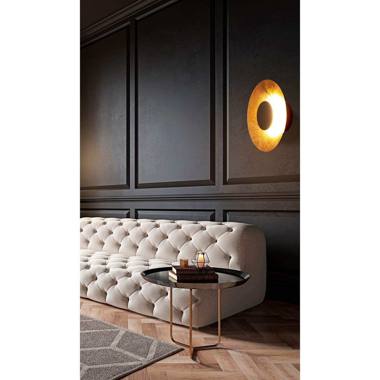 Mantra Orion semi-flush ceiling light illuminated on a dark panelled wall above a tufted cream sofa, showing its gold leaf interior and matt black dome.