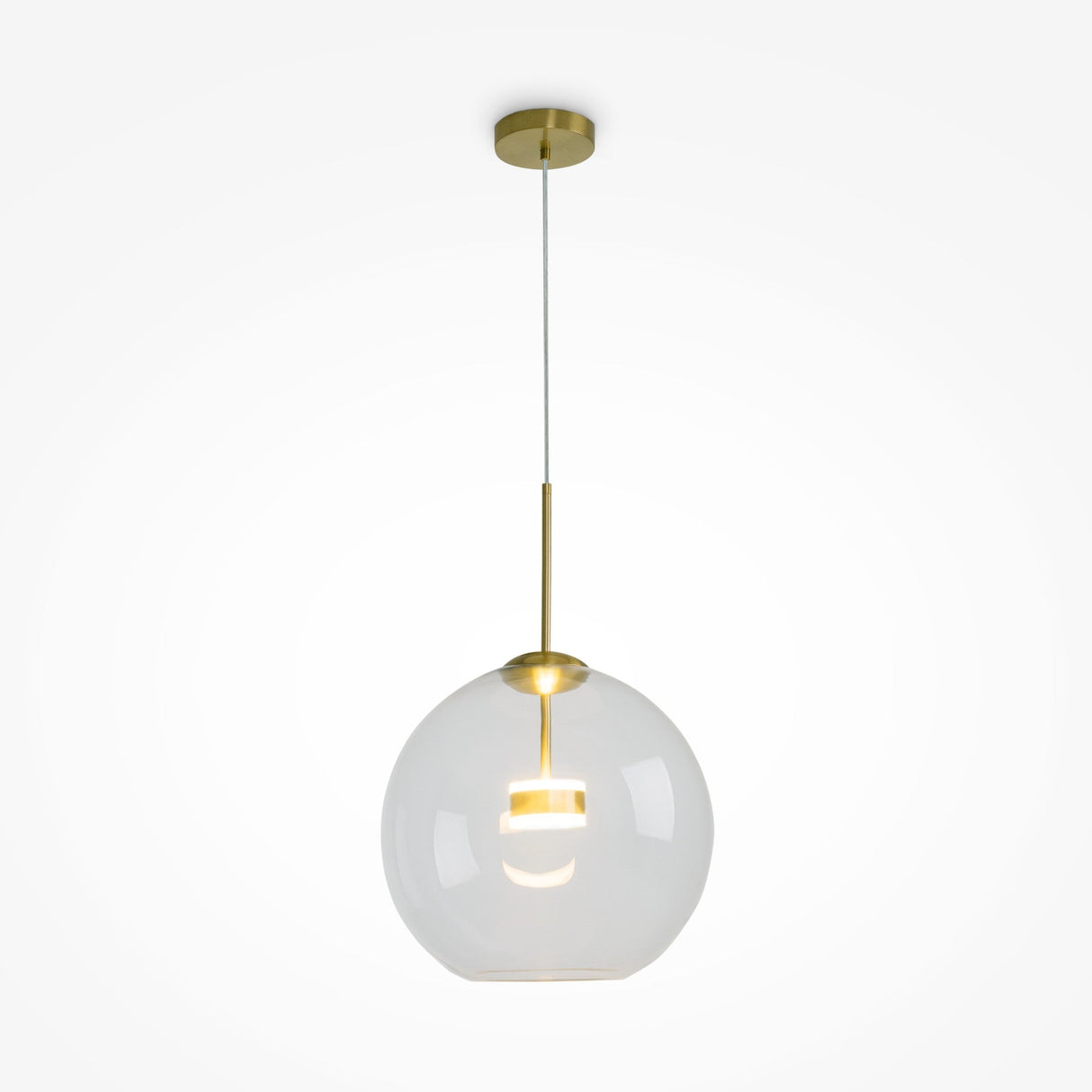 The Cometa LED Pendant Light in brushed gold features a clear glass globe, suspended from a brass rod and ceiling mount, providing a warm glow.